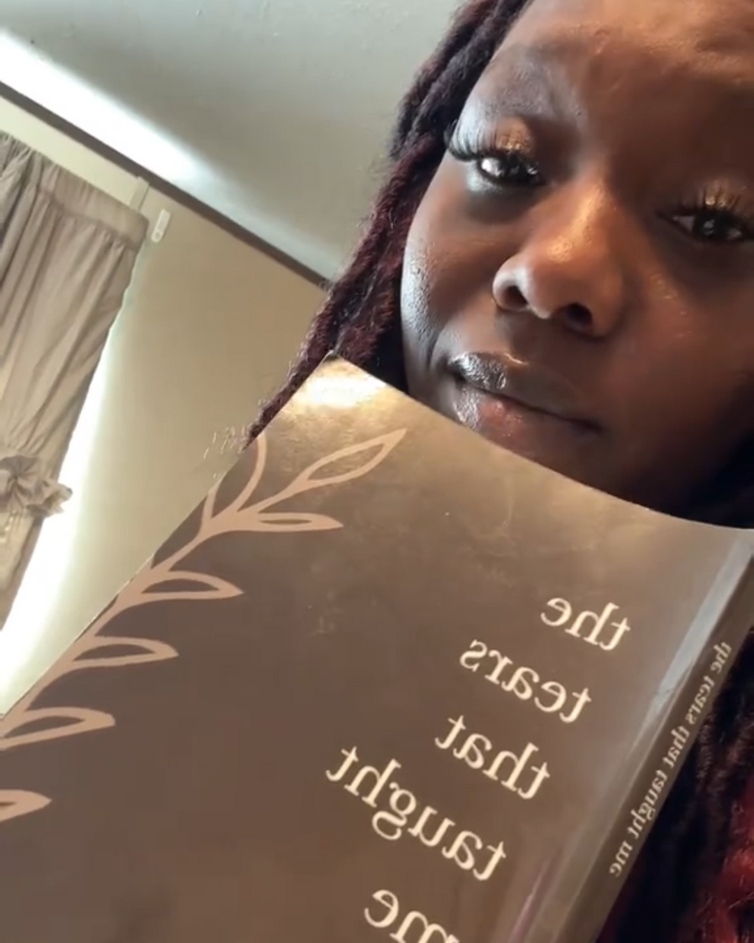 Reader holding a book titled 'The Tears That Taught Me' by Morgan Richard Olivier